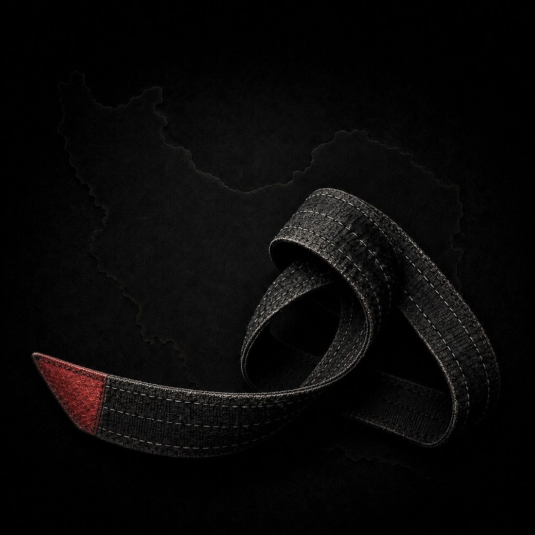 A worn black belt with a red tip, photographed over a map of Iran